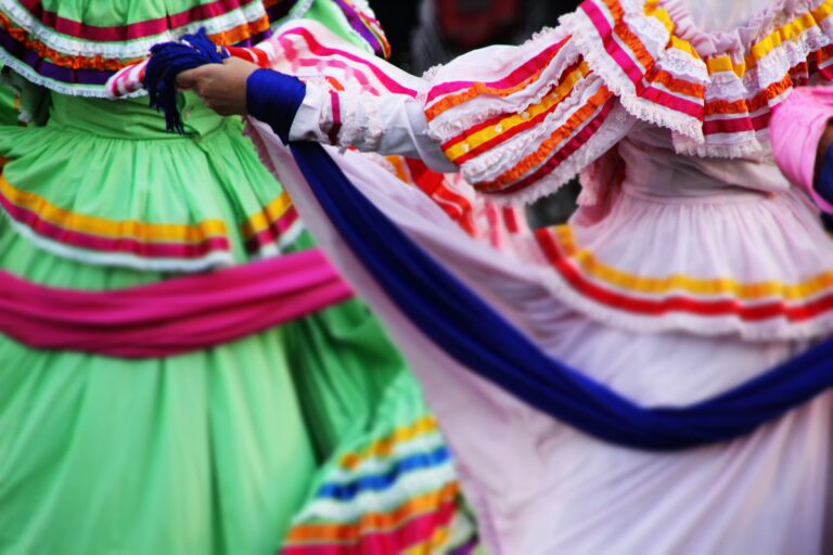 Group of Mexican folk dancers in festive costumes gather together for the celebration